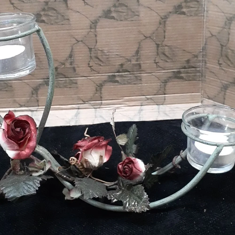 Long 3 candle black iron candle holder laced with trailing red roses.‎